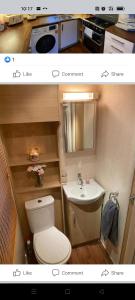 a small bathroom with a toilet and a sink at Holiday home sleeps six in Poole