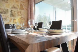 a wooden table with plates and glasses on it at Villa Evdokia II in Makry Gialos