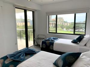 a bedroom with two beds and a large window at Serenity Splendour at Darwin Waterfront in Darwin