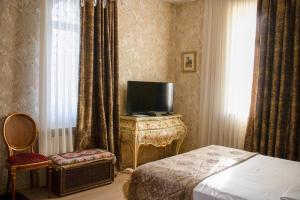 a hotel room with a bed and a television at La Casa Old City Hotel in Baku