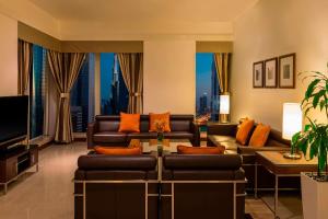 sala de estar con sofás y TV de pantalla plana. en Four Points by Sheraton Sheikh Zayed Road, en Dubái
