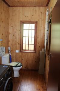 een houten badkamer met een toilet en een raam bij Bush break @ 3990 Marloth Park in Marloth Park