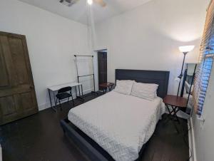 a bedroom with a bed and a desk and a door at Villas de Frenchmen in New Orleans
