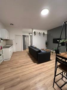 a living room with a black couch and a kitchen at mamila apartment in Jerusalem