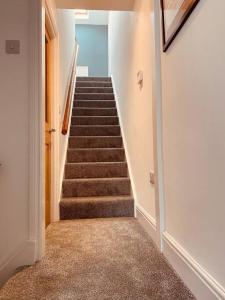 a hallway with a stairway with a stair case at Luxury 2 bed apt 4 mins from M6 J44 pet friendly, in Carlisle