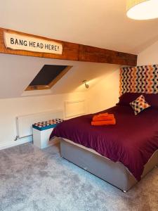 a bedroom with a bed and a sign that reads bang head here at Luxury 2 bed apt 4 mins from M6 J44 pet friendly, in Carlisle