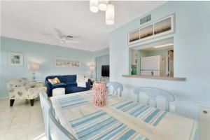 a dining room and living room with a table and chairs at Coastal Cheer in Bradenton Beach