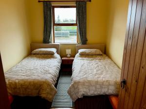 two beds in a small room with a window at Bloomfield Steading in Laurencekirk