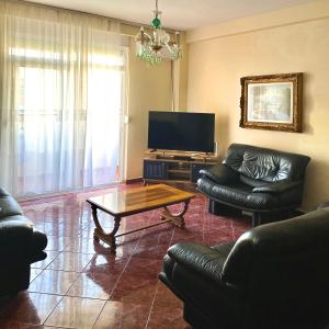 een woonkamer met banken en een tafel en een televisie bij Sea View Apartaments in Durrës