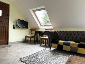 a living room with a couch and a window at Forest Studio Apartment gated Parking on 2 acres Garden in Chislehurst