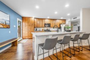 Scottsdale Modern في سكوتسديل: مطبخ مع خزائن خشبية وبار مع الكراسي