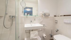 a bathroom with a shower and a sink and a toilet at Hotel Steffl Garni in Ruhpolding