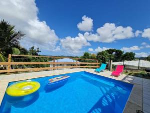 - une piscine avec 2 chaises et un frisbee dans l'établissement Idéal groupe : Villa 150m2 + piscine + vue mer, à La Trinité
