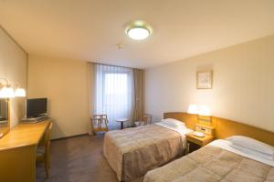 Postel nebo postele na pokoji v ubytování Sky Hotel Uozu Annex + 20 fotografií