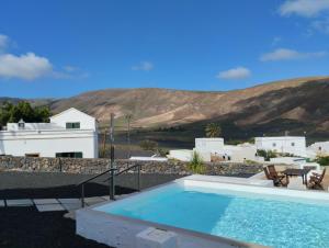 een zwembad met uitzicht op een huis en de bergen bij Casa Pancho in Tabayesco