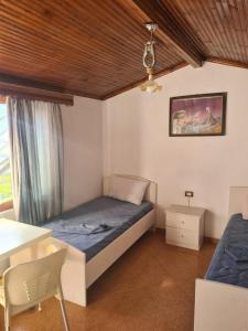 a bedroom with a bed and a table and a chair at Guest House Ilir in Berat