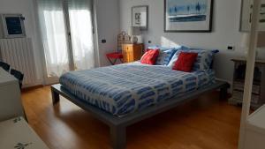 My b&b - Strada Vecchia del Pinocchio 3/B في أنكونا: غرفة نوم بسرير ومخدات زرقاء وحمراء