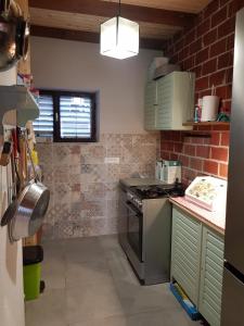 a kitchen with a stove and a brick wall at Sunny Bay House in Kotor
