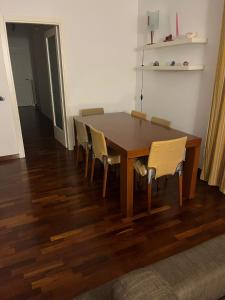 uma mesa de madeira e cadeiras numa sala de estar em RG HOUSE em Trani