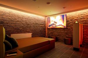 a living room with a couch and a flat screen tv at Privé Spa L'amour in Nuenen