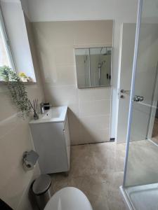 a white bathroom with a toilet and a mirror at mamila apartment in Jerusalem +13 photos