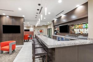 a bar in a hotel room with a counter and chairs at TownePlace Suites Dallas Plano/Richardson in Plano