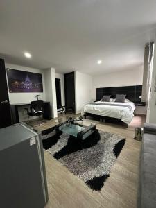 een woonkamer met een bed en een bank bij HOTEL JARDIN 38 in Pasto