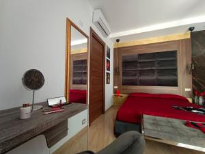 1 dormitorio con cama roja y espejo en Diamond, en Randazzo