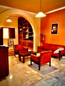 una sala de estar con muebles de color rojo y un arco en Dom Alberto Hostel en Corumbá