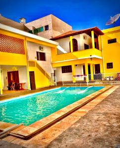 a house with a swimming pool in front of a house at Dom Alberto Hostel in Corumbá