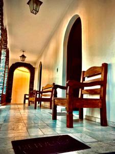 a hallway with two wooden benches in a building at Dom Alberto Hostel in Corumbá