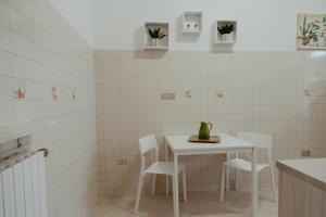 a white tiled kitchen with a white table and chairs at La casa di Grazia in Rome