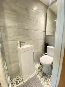 a bathroom with a toilet and a sink at Cozy En-suite near Stratford in London