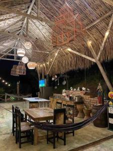 a restaurant with a table and a straw roof at finca playa seca in Santa Fe de Antioquia