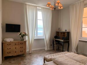a bedroom with a bed and a desk and a television at Spiaggia Amore - Appartamenti Vacanza Vista Lago in Cannobio