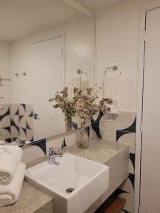 y baño con lavabo blanco y espejo. en Garvey Park Hotel - Quarto Premium 409 en Brasilia
