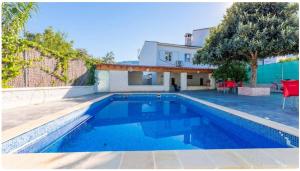 a swimming pool in front of a house at Casa Rural El Níspero in Cortes de la Frontera