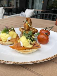 a plate of food with potatoes and tomatoes on a table at Marriott Dallas Uptown in Dallas