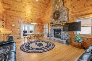 a living room with a stone fireplace in a log cabin at Papaw's Bear Den in Pigeon Forge
