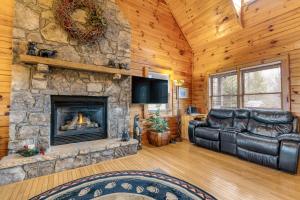 a living room with a stone fireplace and leather furniture at Papaw's Bear Den in Pigeon Forge