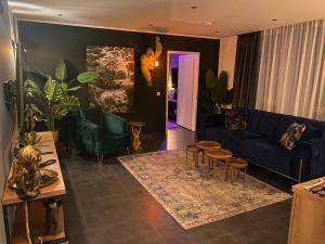 ein Wohnzimmer mit einem blauen Sofa und Stühlen in der Unterkunft MARRAM Suitehotel in Münster