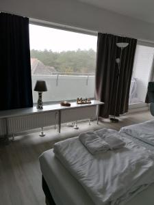 ein Schlafzimmer mit einem Bett und einem Schreibtisch vor einem Fenster in der Unterkunft SPO - gemütliches Apartment - TOP LAGE in Sankt Peter-Ording