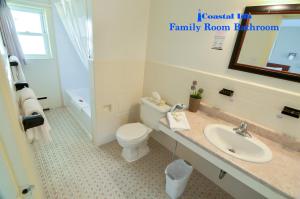 a bathroom with a white toilet and a sink at Coastal Inn Antigonish in Antigonish