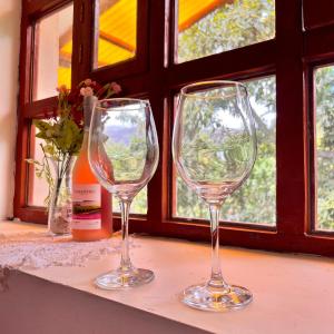 two empty wine glasses sitting on a window sill at Posada Del Valle Lodge in Urubamba