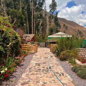 a stone walkway with a hose in a garden at Posada Del Valle Lodge in Urubamba