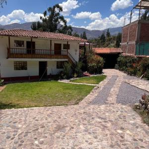a house with a stone walkway in front of it at Posada Del Valle Lodge in Urubamba