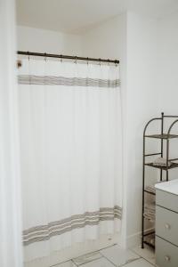a white shower curtain in a bathroom with a shelf at Happy Trails West Inn in Tropic