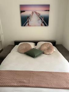uma cama com duas almofadas e uma foto de um cais em Joli Studio à Sanary-sur-Mer em Sanary-sur-Mer
