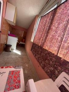 een kamer met een gordijn, een tafel en een raam bij Apartments Zeneva in Donji Štoj