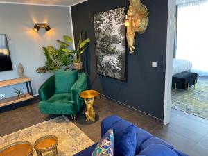 a living room with a blue couch and a green chair at MARRAM Suitehotel in Münster